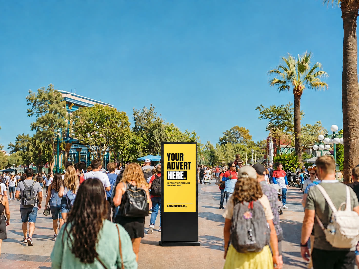 Families walking past a Longfield Media digital totem showing an advert at a busy attraction.